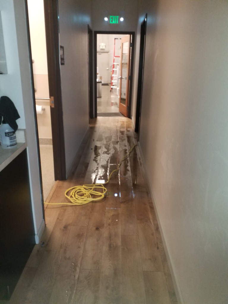Flooded multi-unit hallway during commercial water mitigation