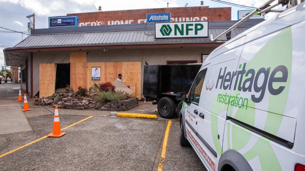 Heritage Restoration crew boarding up a commercial storefront